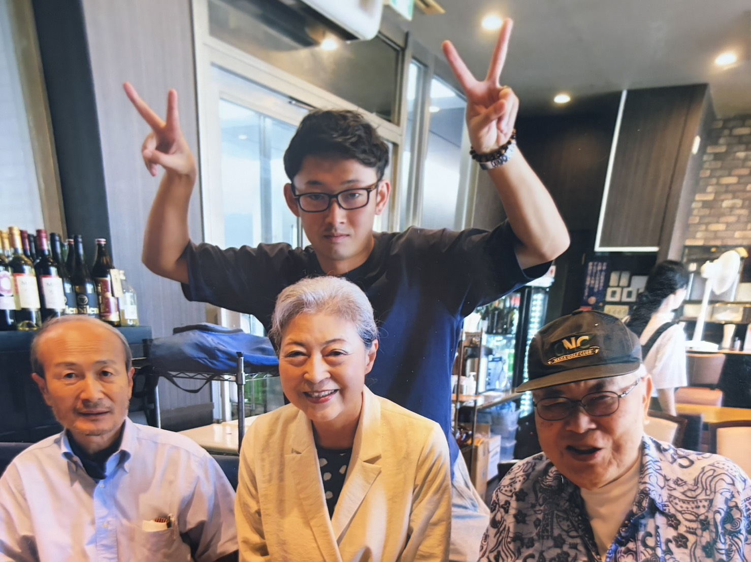 世代の異なる4人が笑顔で並ぶ集合写真